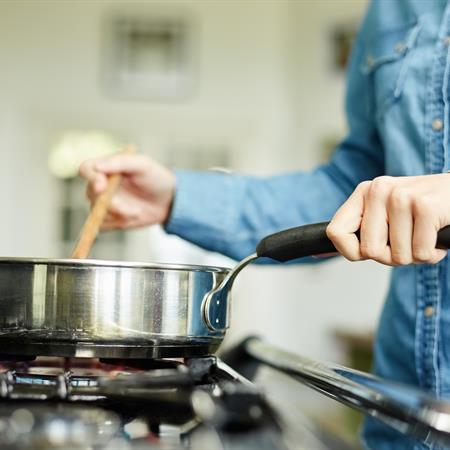 Woman cooking with natural gas on stove top